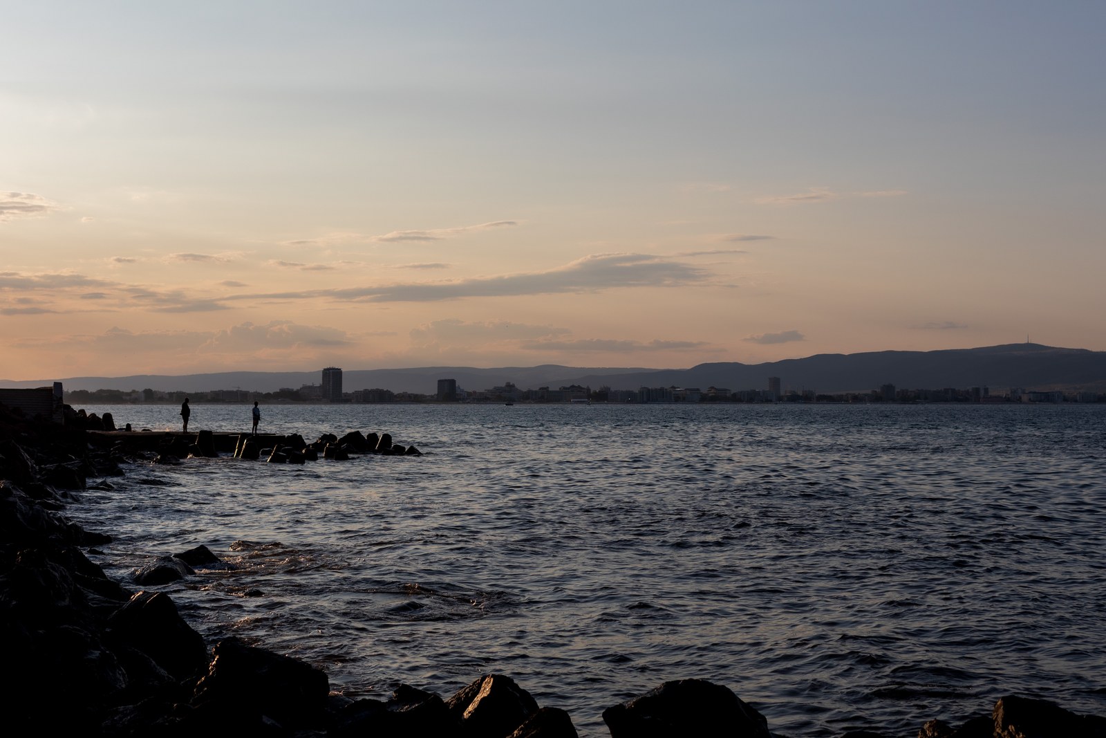 Sunset over the bay with fishermen in silhouette