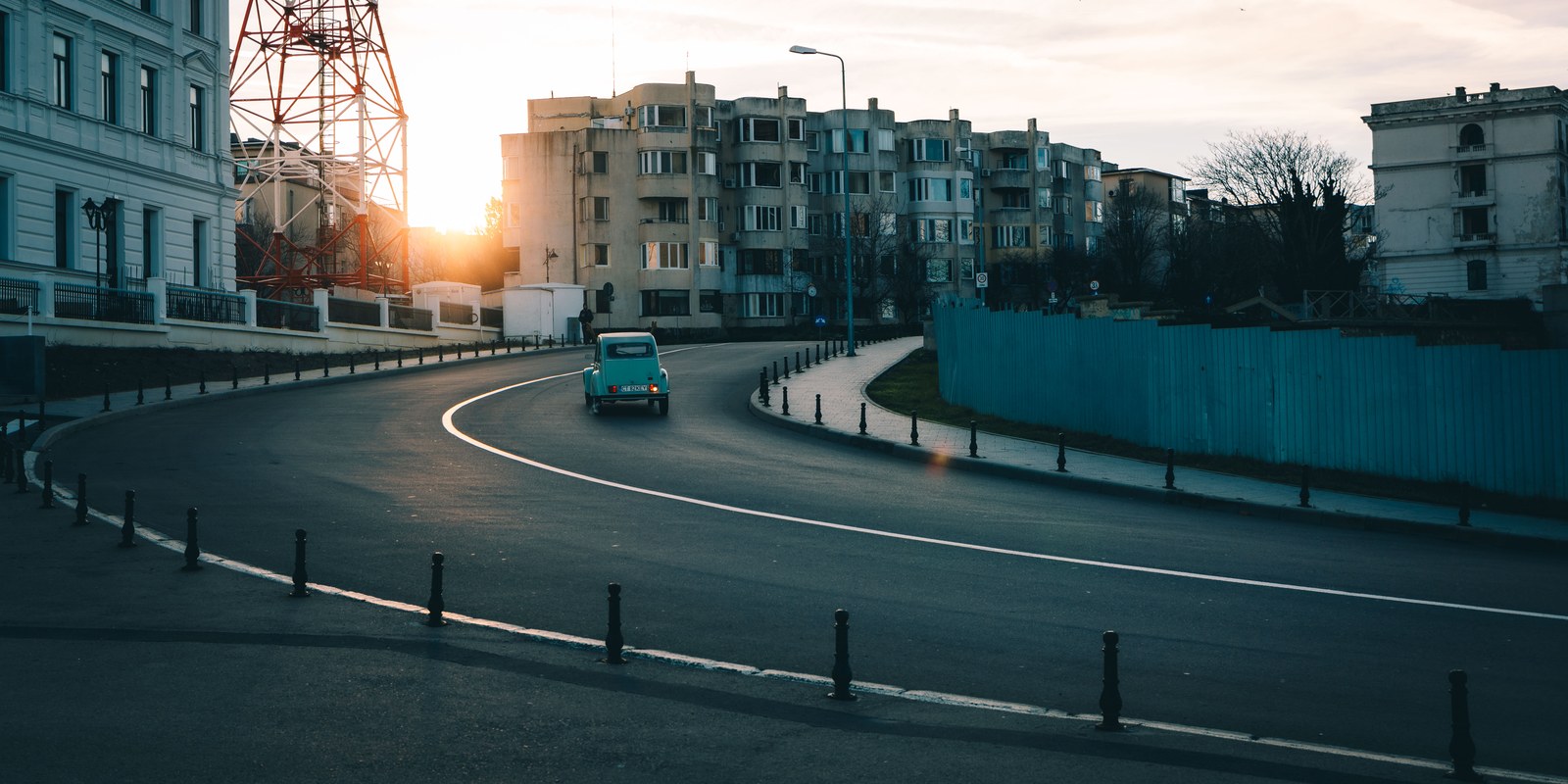 Vintage car on a curved city street at sunset